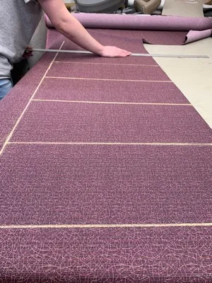 Chalking the fabric ready for cutting — pattern alignment marked on the bench