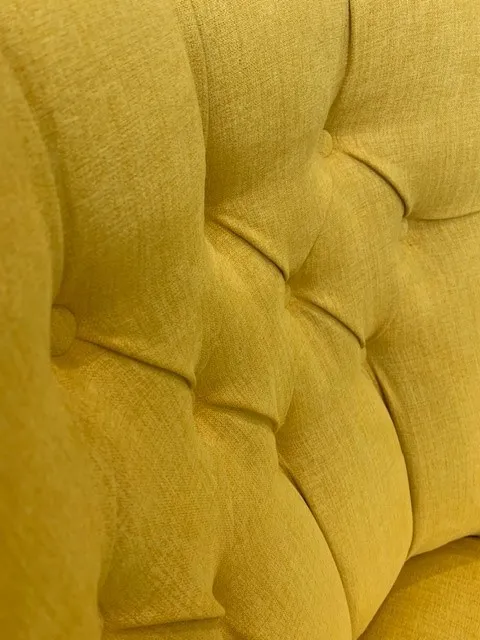 Detail of gold chair back panel and tufting