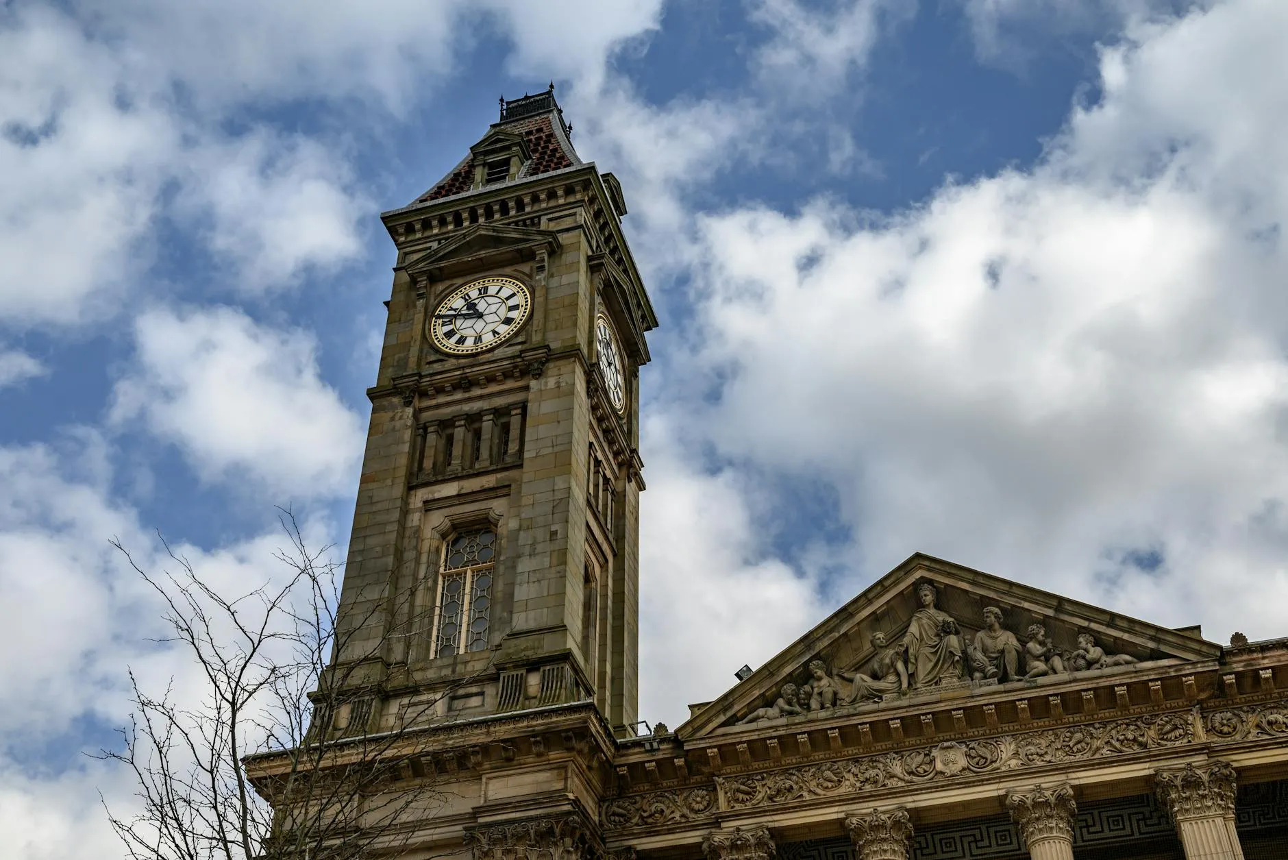 View of the historic Bolton Town Hall clock tower against a cloudy sky in England. — covered by Valley Upholstery's Stalybridge route
