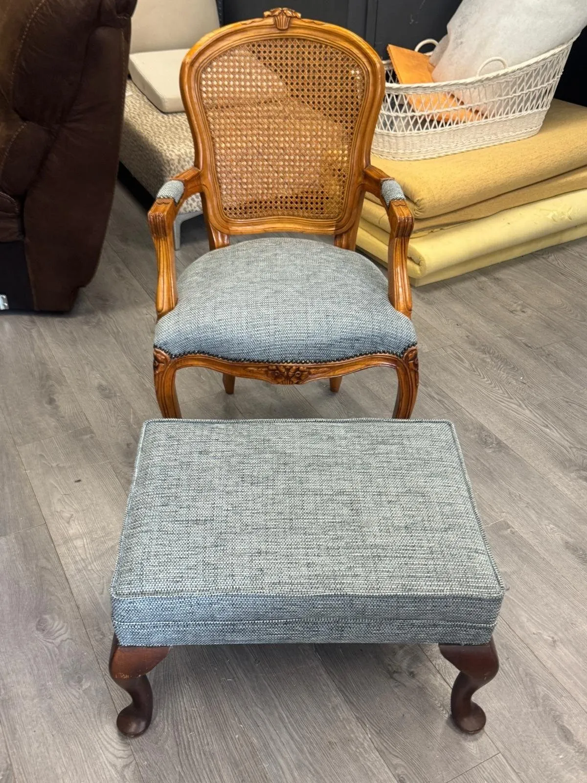 The same cane-back armchair recovered in blue-grey weave, with its matching footstool