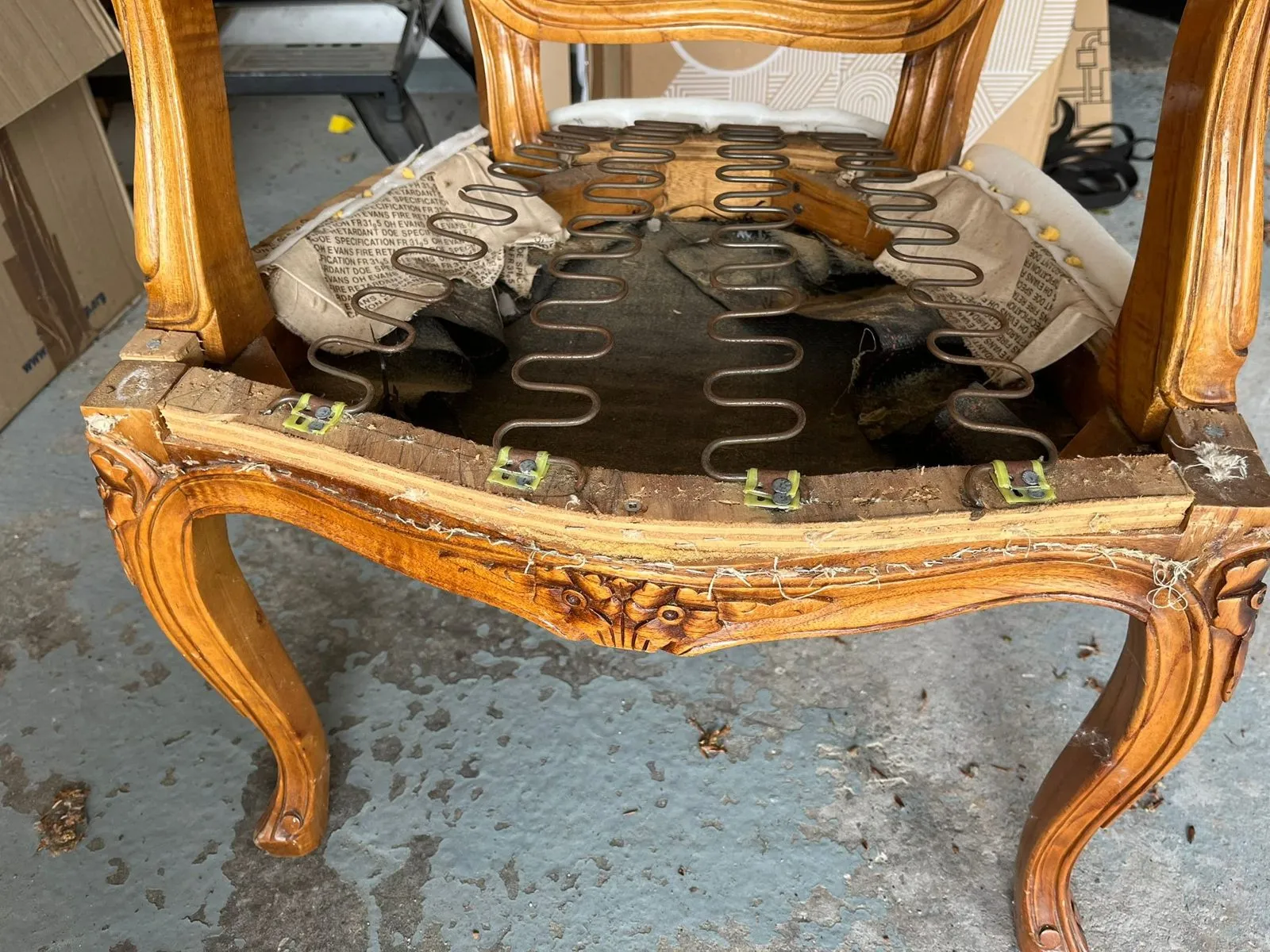 Close view of the carved seat rail and serpentine spring bed before re-stuffing
