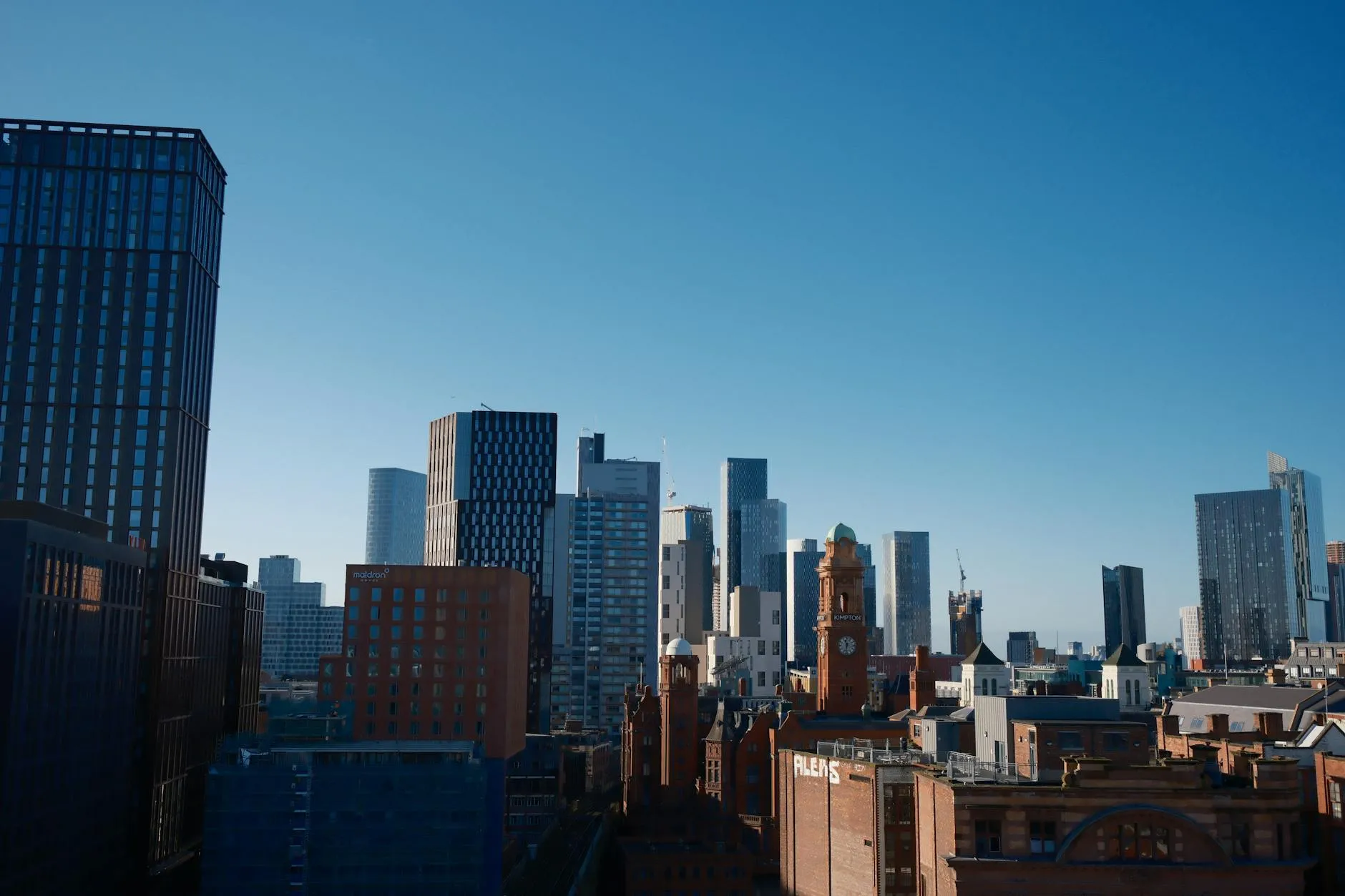 Skyline of Manchester city featuring the iconic Beetham Tower under a bright blue sky. — covered by Valley Upholstery's Stalybridge route