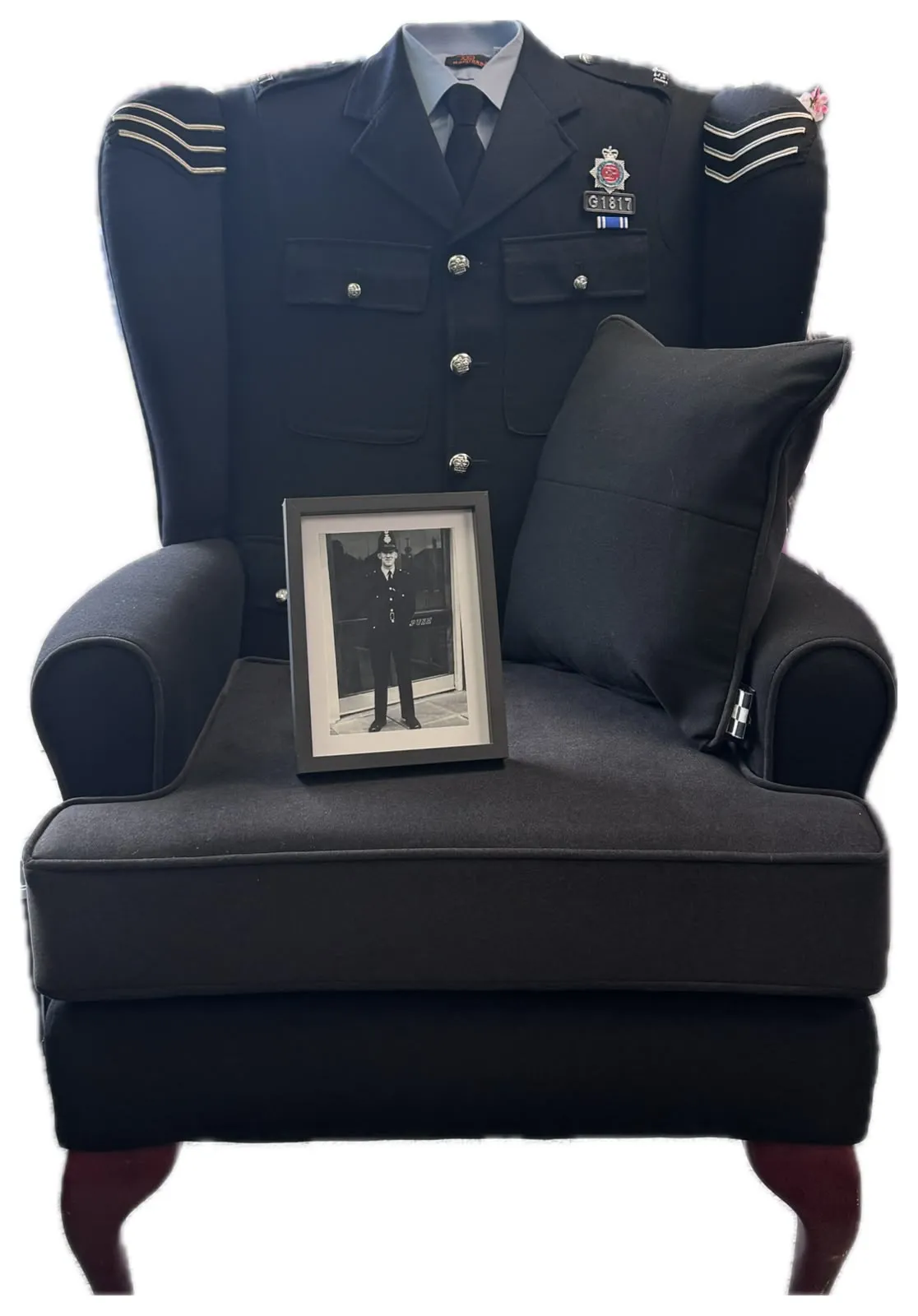 Wingback armchair upholstered in Greater Manchester Police uniform wool, styled with the service tunic, photo and cushion