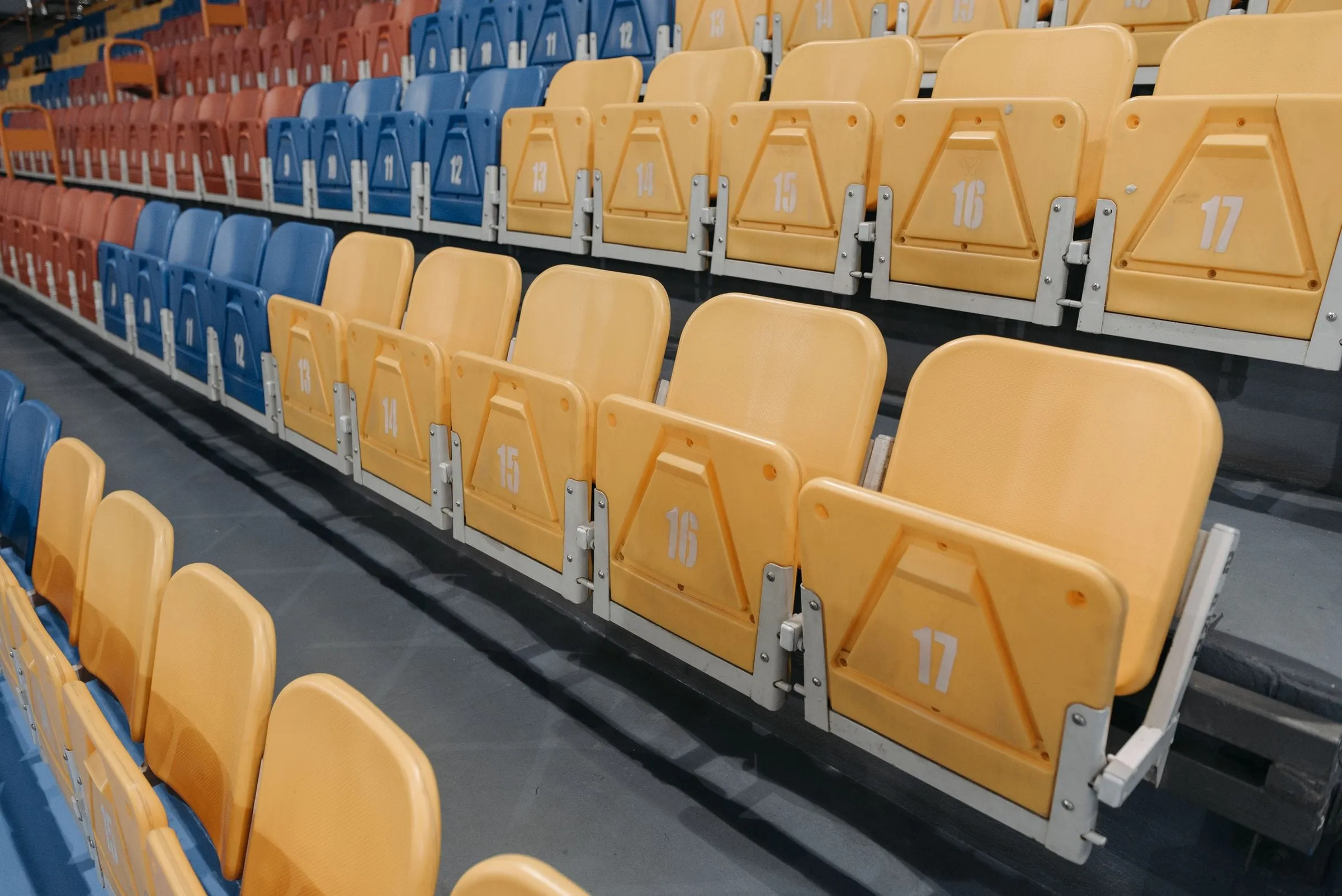 Representative rows of numbered tip-up stadium seats in club colours