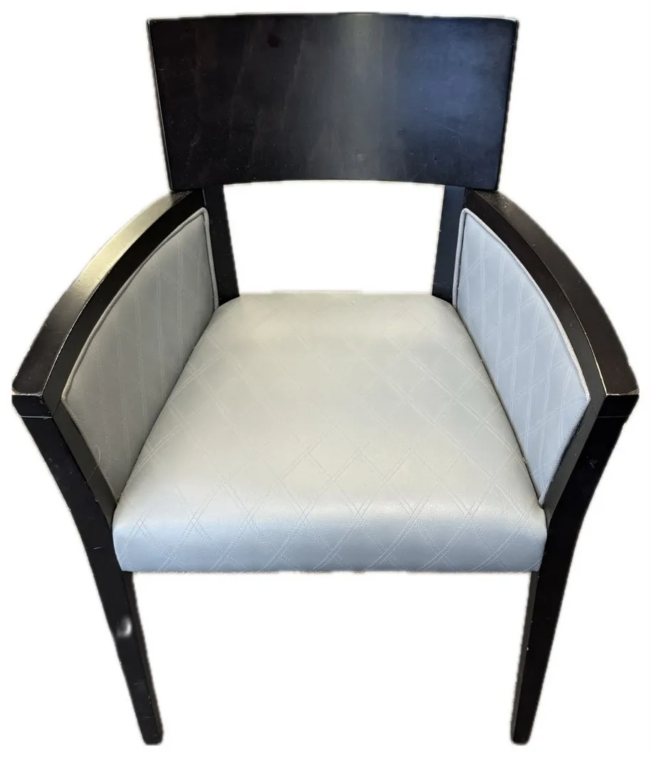 Open-back dining chair with grey diamond-stitch faux leather seat and side panels in a dark timber frame